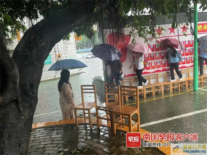 点赞！南宁一学校老师雨中赤脚蹚水，用凳子为学生搭桥(图1)
